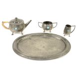An English pewter tea service with planished finish and Ruskin roundels, with matching tray,