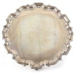George V silver salver with pie crust border, on three scroll feet, engraved with signatures, by