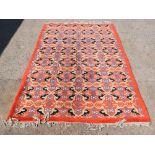Moroccan red ground carpet, with repeating medallions 249cm x 152cm .