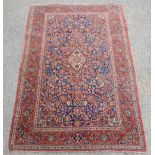 Persian red ground rug with a central medallion surrounded by flowers and multiple borders, 202cm
