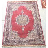 Indian red ground wool rug with multiple borders the centre with a central medallion 215cm x 157cm .