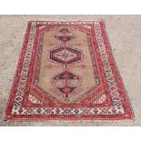Sarib red ground rug with multiple borders, the centre with a shaped medallion, 185cm x 112cm .