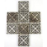 Eight Minton & Co Arts and Crafts encaustic tiles, each foliate decorated in white against a black