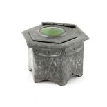 Hammered pewter inkwell of hexagonal form with central green Ruskin type roundel to the lid,