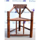 An early 20th Century oak Turners chair, with carved roundel back over a triangular plank seat and