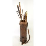 Early 20th century leather shell carrier and a collection of swagger sticks .