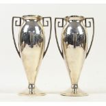 Pair of silver vases of elongated ovoid form, on round bases,