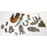 Group of Omani white metal items to include a bracelet and pendants, and a dagger in leather sheath