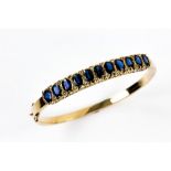 Vintage sapphire set gold bangle, in scroll mount, with hinged mechanism, 9 ct gold, internal
