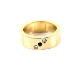 Contemporary gold wedding band set with one round cut sapphire and two round brilliant cut diamonds,