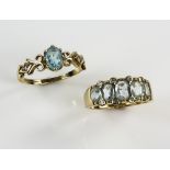 Two blue topaz rings, a five stone ring with diamond accents and another with single stone, both 9