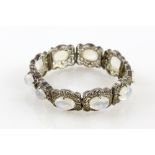 Early 20th C moonstone panel bracelet with ten cabochon stones in filigree decorated mounts,