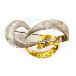 Vintage abstract brooch in white and yellow textured gold set with small brilliant cut diamonds .