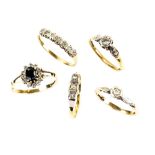 Five gold rings, one with an illusion set diamond, size M, another three stone diamond, size N, both