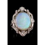 Opal and diamond dress ring, central oval cabochon cut opal, 13 x 11mm, surrounded by compass set