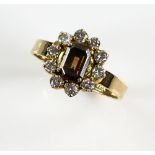 Cognac fancy coloured diamond dress ring, the central emerald cut stone within a border of white