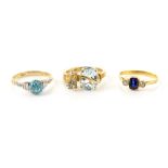 Three gold dress rings, an aquamarine and diamond set ring, another set with blue zircon, both 9