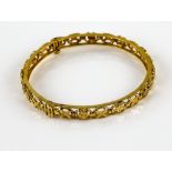 Indian gold bangle, with openwork flower and cross design, and hinged with screw fitting, testing as