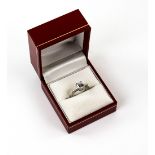Diamond ring, set with a central emerald cut diamond, estimated weight 1.00 carat, with two