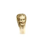 An ivory cane or parasol handle carved with a grotesque head, 6 cm high, 20th CenturyProvenance: The