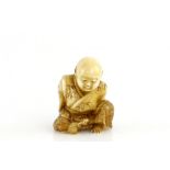 A stained ivory netsuke of the young Sesshu, seated beside his rat at The Sokokuji Temple, signed