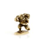 An ivory netsuke or small okimono, carved as a running Oni with a bag of makemono, unsigned, 19th