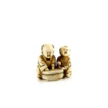 An ivory netsuke of two boys beside a circular tub of water, signed HominProvenance: The Property of