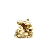 A large netsuke of Ebisu holding a Tai Fish with his right hand and pouring sake for Hotei with