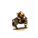 An ivory netsuke of a boy seated on a water buffalo; the base with a single himotoshi; signed