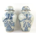 A pair of Imari, underglaze blue decorated vases; each one with domed cover and decorated with