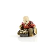 A Yasuaki (Homei) School coloured ivory netsuke of a seated boy with articulated head, eating from a