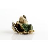 A Yasuaki (Homei) School coloured ivory netsuke of Hotei trying to avoid a large black rat on his
