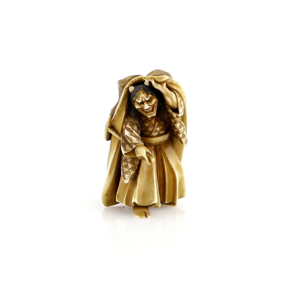 A small lacquered ivory okimono of a Noh, or other theatre, performer in the role of Hannya;