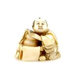 A stained ivory netsuke of a seated man with O-mochi cakes, signed Shuzan in an oval reserve.