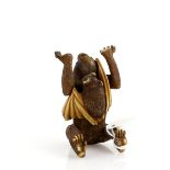 A heavily stained ivory okimono of a monkey, holding up both hands and being startled by a bat,