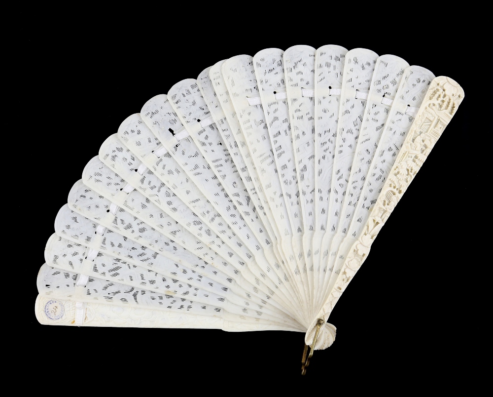 A Cantonese ivory fan with 20 sticks; each stick of typical reticulated form carved with designs