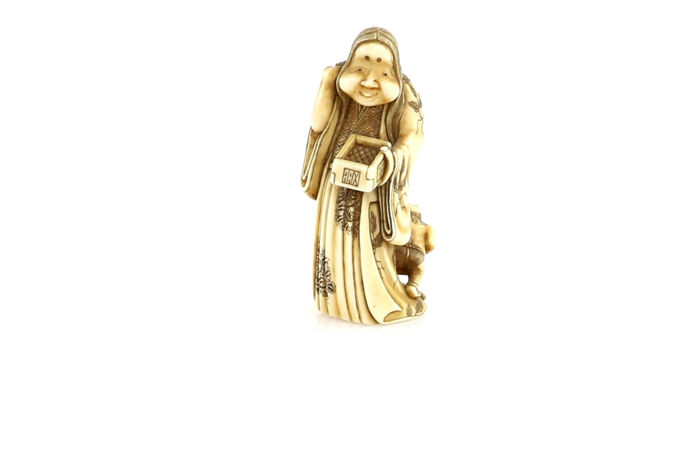 An ivory netsuke or small okimono of Okame, throwing Soy beans during the Annual Setsubun Festival