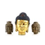 A heavily gilded metal head of Sakyamuni (The Historical Buddha) with long pendulous ears and with