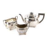 George V silver three piece tea service, comprising teapot, cream jug and sugar bowl, with a