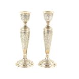 Modern Persian pair of silver candlesticks, chased with scrolls, on circular bases, 22cm high, 13.