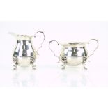Sterling silver cream jug and bowl, both with flared rims and on four lion-mask capped feet, 10 cm