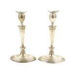 Pair of George V silver presentation candlesticks, on elliptical bases and knopped stems, by