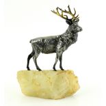 Silver plated stag with gilded antlers on a white glass outcrop 20cm.