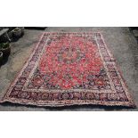 Persian type red ground carpet, with a main blue border, the centre with repeating foliate forms and