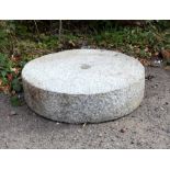 A granite millstone, 57cm diameter,.