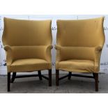 Pair of 18th century style wing back arm chairs on mahogany legs . Both structurally sound, with