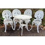 Cast metal garden table, diameter 70cm and four chairs .
