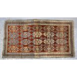 Persian type red ground rug with multiple borders, the centre decorated with repeating foliate
