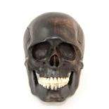 German school, late 19th century skull, ebony with bone teeth, 9.5cm high. Splits and cracks as
