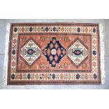 Red ground Persian type rug with a main cream border, the centre with three shaped medallions